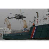 Vol stationnaire d'un hélicoptère Lynx au-dessus de l'Alcyon dans le port de Brest et sortie de la corde lisse.