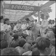 Le roi du Cambodge Norodom Sihanouk et des autorités distribuent des tissus à la population lors d'une visite à Mongkol Borey.
