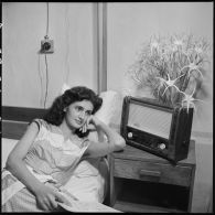 Christiane Sacquet, infirmière, écoutant la radio sur son lit.