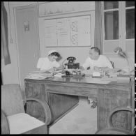 Le médecin-colonel Petchot Bacque dicte et l'infirmière Christiane Sacquet travaillant dans un bureau.