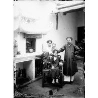 Na-Huong-Maï, incrusteur rue Jules Ferry et ses enfants. [légende d'origine]