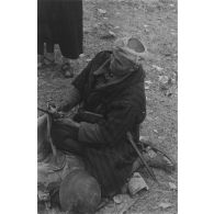 Un goumier d'un goum du 2e groupe de tabors marocains (2e GTM) entretient sa baïonnette sur un temps de repos.