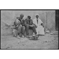 Soldat prenant le thé avec deux hommes et un enfant.