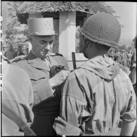 Le général Navarre, commandant en chef en Indochine, décore un parachutiste qui s'est distingué au cours des premiers combats à Diên Biên Phu.