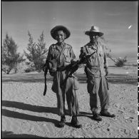 Deux tirailleurs indochinois du 1er REC (régiment étranger de cavalerie) posent fièrement avec les munitions et une mitrailleuse Viêt-minh qu'ils viennent de récupérer au cours de l'opération Caïman.