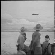 Largage de caisses de ravitaillement depuis un avion Junkers Ju-52 en zone côtière près de Hué au cours de l'opération Caïman.
