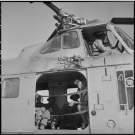 Son inspection terminée, le colonel Then quitte Muong Khoua à bord de l'hélicoptère qui ramène des blessés. Au poste de pilotage, le capitaine Faroux.
