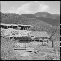 Les villageois de Muong Khoua reconstruisent leurs paillotes détruites par le vietminh après que le village ait été libéré par les troupes françaises.