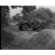 Normandie 1944 (actualités américaines) - Matériel militaire allemand découvert par des soldats américains ; convoi de troupes américaines dans Faverolles.