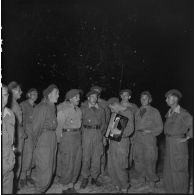 Après la messe de minuit à Diên Biên Phu, des légionnaires de la 13e demi-brigade de Légion étrangère (DBLE) chantent des cantiques devant le sapin.