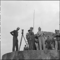 Monté sur un blockhaus, le général Navarre observe les environs au cours d'une inspection au poste de Yen Cu.