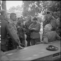 Le général Navarre écoute le récit des premiers combats menés par les parachutistes dans le cadre de l'occupation de la vallée de Diên Biên Phu par le colonel Fourcade.