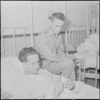 Le cameraman André Lebon, blessé à Diên Biên Phu, s'entretient avec le photographe Jean Petit pendant sa sonvalescence à l'hôpital Grall de Saigon.