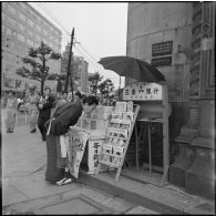 Marchande de journaux dans une avenue de Tokyo.