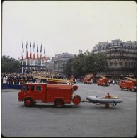 Défilé motorisé lors de la cérémonie du 14 juillet 1979 à la Bastille. Passage des véhicules de la brigade des sapeurs-pompiers de Paris (BSPP) : un plongeur à bord d'un canot de sauvetage léger Zodiac tracté par une camionnette passe devant la tribune présidentielle.
