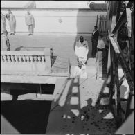 Embarquement du général Cailles à bord du paquebot le Kairouan après une prise d'armes sur l'esplanade de la gare maritime d'Alger.