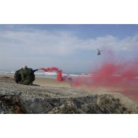 Des stagiaires actionnent leur fumigène sur la plage pendant l'arrivée d'un Puma SA-330 SAR.