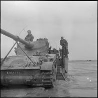 Un char AMX 13 débarque d’une barge. [Description en cours]