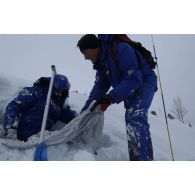 Un maître-chien du PGHM (peloton de gendarmerie de haute montagne) extrait un victime ensevelie sous la neige, lors d'un exercice de recherche après avalanche à Pierrefitte-Nestalas (Hautes-Pyrénées).