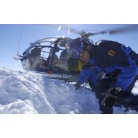 Des membres du PGHM (peloton de gendarmerie de haute montagne) transportent un blessé sur une civière dans l'hélicoptère Alouette III lors d'un exercice de secours sur le Soum de Léviste, sommet des Hautes-Pyrénées situé à 2437 mètres d'altitude.