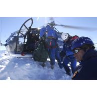 Des membres du PGHM (peloton de gendarmerie de haute montagne) transportent un blessé sur une civière dans l'hélicoptère Alouette III lors d'un exercice de secours sur le Soum de Léviste, sommet des Hautes-Pyrénées situé à 2437 mètres d'altitude.