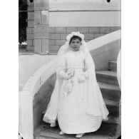 100. [Algérie, 1905-1914. Portrait d'une jeune fille en robe de communiante.]