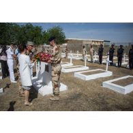 Le général de division Jean-Pierre Palasset, commandant la force Barkhane, accompagné de madame Evelyne Decorps, ambassadrice de la France au Tchad, dépose une gerbe de fleurs au monument aux morts du cimetière de Farcha dans la périphérie de N'Djamena, lors de la cérémonie du 11 novembre 2014.