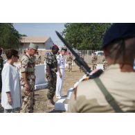 Le général de division Jean-Pierre Palasset, commandant la force Barkhane, accompagné de madame Evelyne Decorps, ambassadrice de la France au Tchad, respecte une minute de silence au monument aux morts du cimetière de Farcha dans la périphérie de N'Djamena, lors de la cérémonie du 11 novembre 2014.