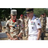 Le général de division Jean-Pierre Palasset, commandant la force Barkhane, s'entretient avec un colonel des troupes de marine dans le cadre d'une  visite du cimetière de Farcha, dans la périphérie de N'Djamena, lors de la cérémonie du 11 novembre 2014.