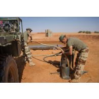 Drainage d'eau au moyen d'une motopompe Musthane par les soldats de la section eau énergie afin de réactiver un ancien puits libyen, lors des travaux de constructions de la nouvelle BOA (base opérationnellele avancée) de Madama.