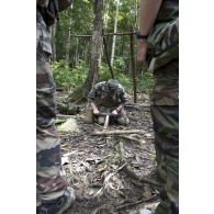 Un instructeur du 9e régiment d'infanterie de marine (9e RIMa) montre comment réaliser un feu de bois à des stagiaires en zone d'instruction de Tuff, en Guyane française.