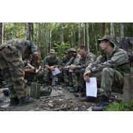 Un instructeur du 9e régiment d'infanterie de marine (9e RIMa) présente différents matériels de transmission en forêt à des stagiaires en zone d'instruction de Tuff, en Guyane française.