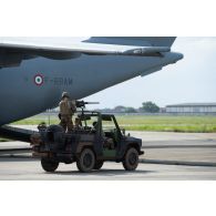 Des marsouins du 43e bataillon d'infanterie de marine (BIMa) embarquent à bord de leur véhicule léger tout terrain (VLTT) Peugeot P4 dans la soute d'un avion A400 M sur l'aéroport d'Abidjan, en Côte d'Ivoire.