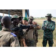 Un instructeur du 2e régiment étranger de parachutistes (REP) présente un fusil d'assaut HK-416 à des élèves sous-officiers ivoiriens à Bouaké, en Côte d'Ivoire.