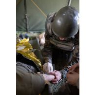 Un élève-praticien s'entraîne à poser une perfusion sur le bras d'un soldat blessé dans une antenne médicale à la Valbonne.