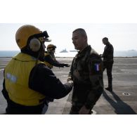 Le général Thierry Burkhard rencontre un chien jaune sur le pont d'envol du porte hélicoptères amphibie (PHA) Tonnerre (L9014) à Sète.
