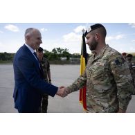 Le secrétaire général de l'OTAN Mircea Geoană salue un officier belge aux côtés du colonel Laurent Luisetti à Cincu, en Roumanie.