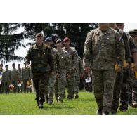 Des récipiendaires retournent dans les rangs après avoir été décorés de la médaille de la Défense nationale échelon bronze lors d'une cérémonie à Cincu, en Roumanie.