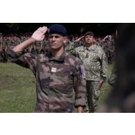 Le colonel roumain Ioan Maria Cristulean salue le lever des couleurs pour la cérémonie de la fête nationale française à Cincu, en Roumanie.