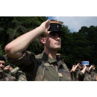 Un commandant d'unité du 35e régiment d'infanterie (RI) salue le lever des couleurs pour la cérémonie de la fête nationale à Cincu, en Roumanie.