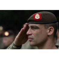 Un commandant d'unité belge du régiment Libération-5e de ligne salue le lever des couleurs pour la cérémonie de la fête nationale française à Cincu, en Roumanie.
