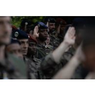 Des soldats saluent le lever des couleurs pour la cérémonie de la fête nationale à Cincu, en Roumanie.