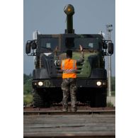 Un soldat du centre de coordination interarmées des transits, transports et mouvements (CCITTM) décharge un camion équipé d'un système d'artillerie (CAESAR) depuis un train en gare de Voila, en Roumanie.