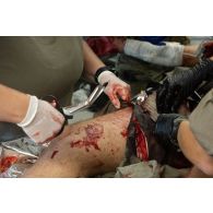 Une infirmière du Service de santé des armées (SSA) soigne un blessé au Rôle 1 de Cincu, en Roumanie.