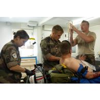 Le personnel du Service de santé des armées (SSA) prépare une transfusion pour un blessé au Rôle 1 de Cincu, en Roumanie.