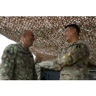 Un officier américain de la 1st multi-domain Task Force discute avec son homologue roumain du 33e bataillon d'infanterie de montagne au centre opérationnel (CO) de la base de Cap Midia, en Roumanie.