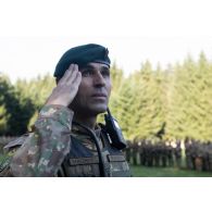 Le colonel roumain Traian Maghercă salue le lever des couleurs pour une cérémonie d'ouverture d'exercice à Brădet, en Roumanie.