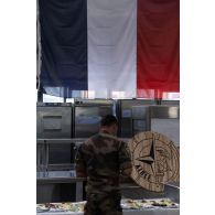 Un soldat français déjeune à l'ordinaire du poste de commandement interalliés lors de la fête nationale à Lunca de Sus, en Roumanie.