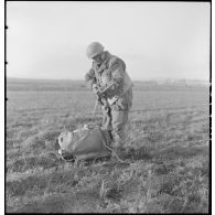 Un parachutiste français monte son arme automatique après avoir atterri sur le sol d'Epernay.