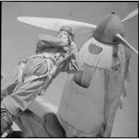 Un pilote du groupe de chasse II/18 Saintonge s'équipe devant son appareil, un Dewoitine D-520.